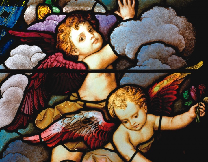 Stained glass close-up of two cherubic angels in the sky