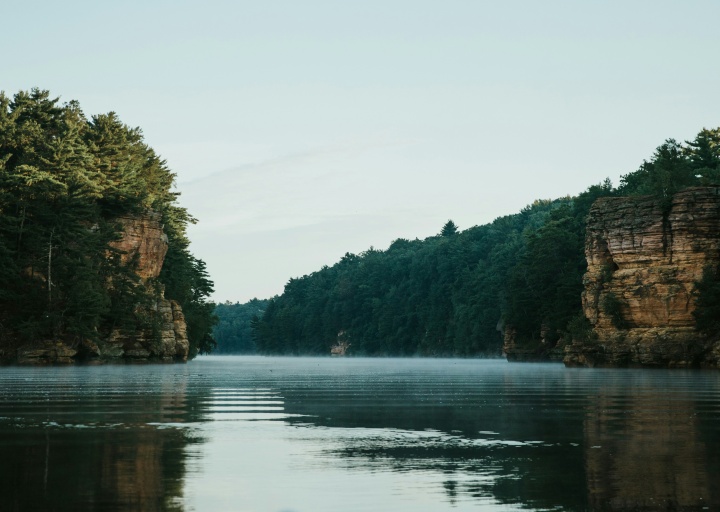 green trees on cliffs above river