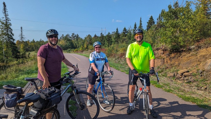 Cyclists standing with their bikes outside