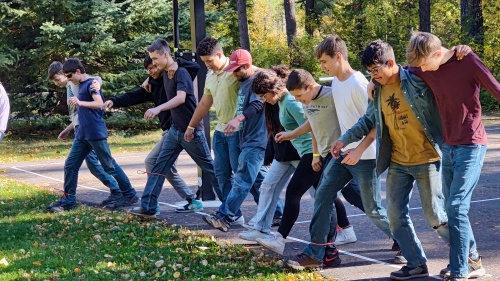 a group of boys participating in a three-legged race