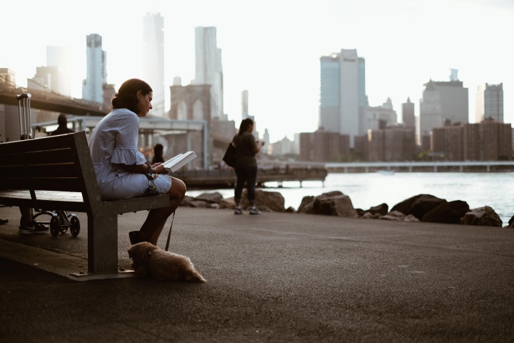 A woman sitting on a bench reading.