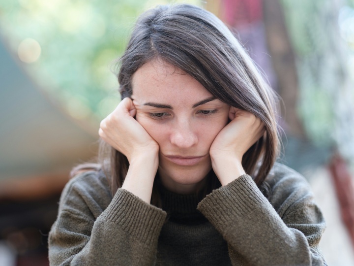 A woman resting her head on her hands.