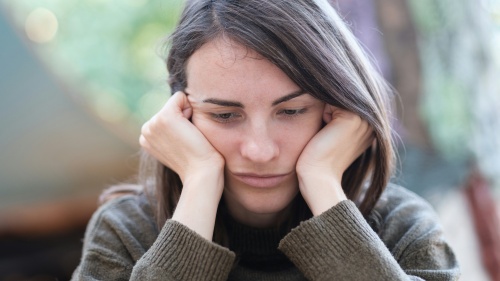 A woman resting her head on her hands.