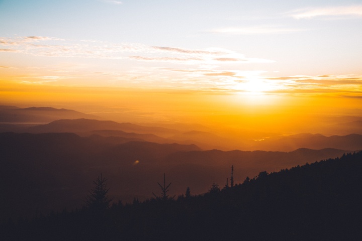 Sun rays shining over hills.