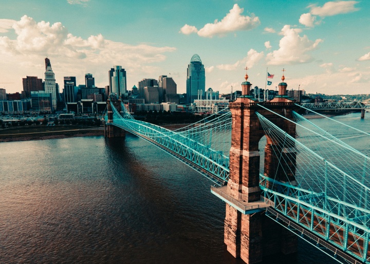 a bridge over a river leading to a city with high-rise buildings