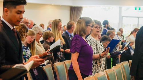 a group of people singing hymns in church