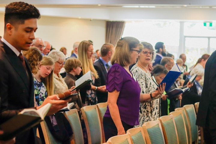 a group of people singing hymns in church