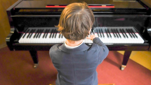 a boy playing a piano