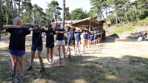 a group of teenage girls with bows and arrows