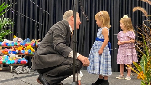 a member speaking with some of the children at the Feast