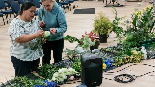 two ladies assembling floral arrangements