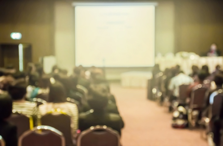 A group of people in a meeting hall.