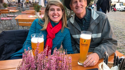 a couple seated outdoors with beers